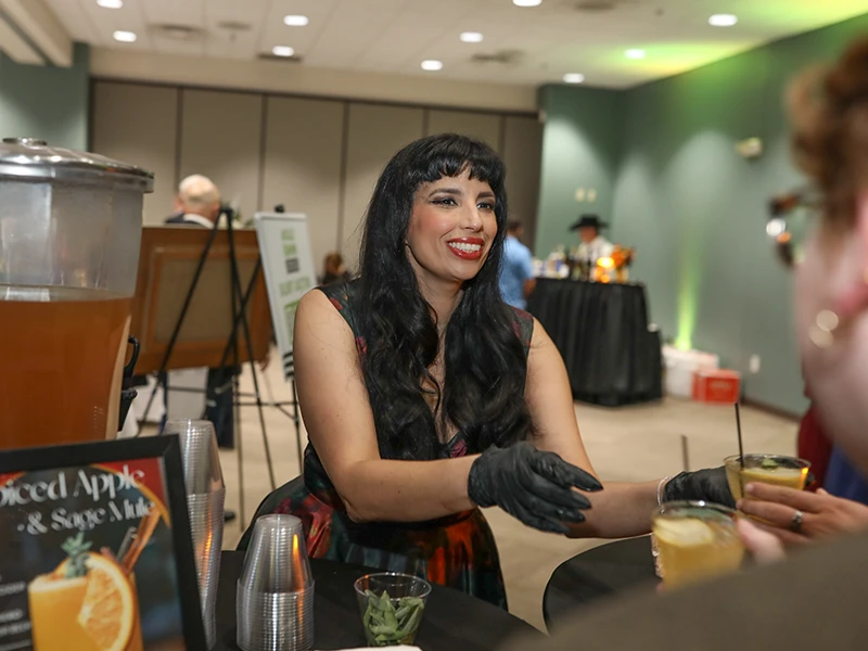 Smiling woman serves cocktail drink.